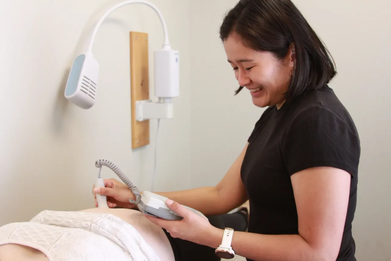 Midwife Brenda using a doppler to listen to a babies heartbeat